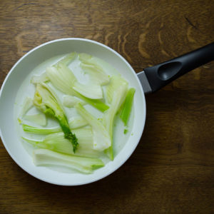 Sliced fennel ready to cook in a frypan